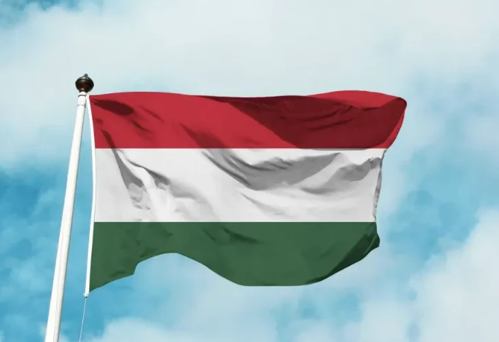 Madžarska zastava sa crvenom, bijelom i zelenom horizontalnom trakom, koja se vijori na jarbolu pod plavim nebom sa oblacima.