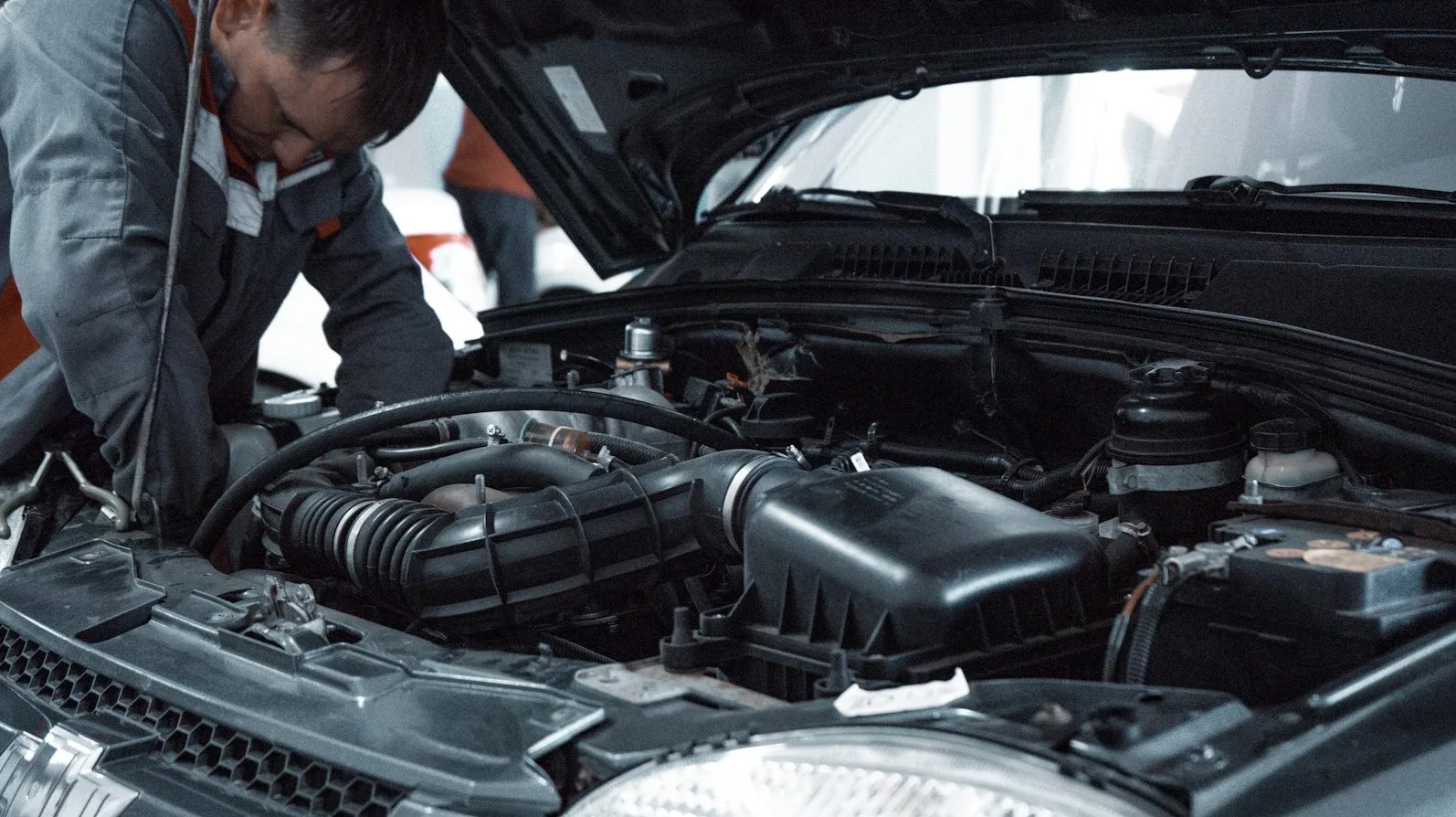 Mehanicar pregleda i radi na motoru automobila otvorenog poklopca