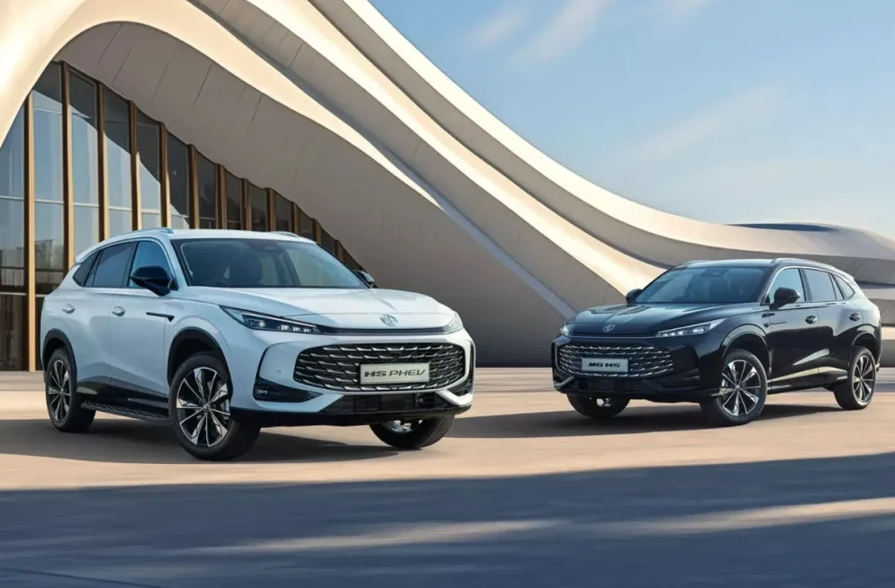 Bijeli MG HS PHEV i crni MG HS PHEV SUV modeli parkirani ispred moderne zgrade