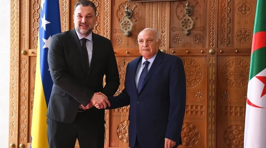 Dva zvaničnika se rukuju ispred zastava Bosne i Hercegovine i Alžira.