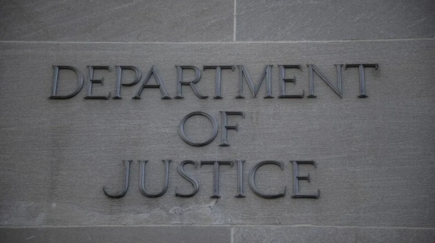 Natpis "DEPARTMENT OF JUSTICE" urezan na kamenu fasadu zgrade.