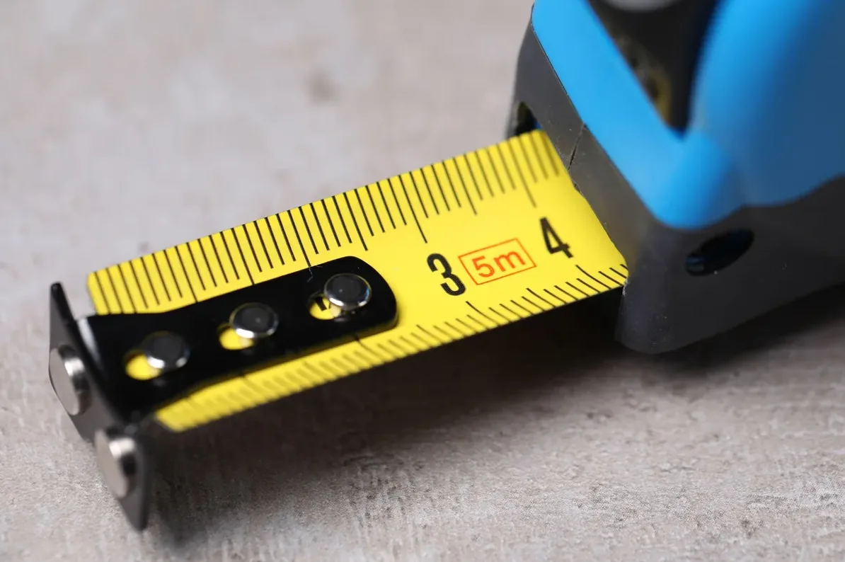 Makro snimak žute mjerne trake sa crnim oznakama i brojevima, sa oznakom 3 i 4 vidljivom, te crvenim okvirom oko 5m.