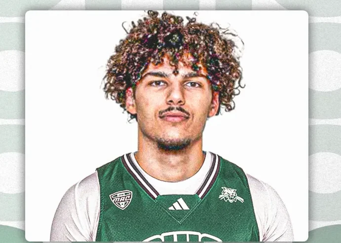 Mladi košarkaš sa kovrdžavom kosom i brčićima, nosi zeleni dres sa grbom kluba.