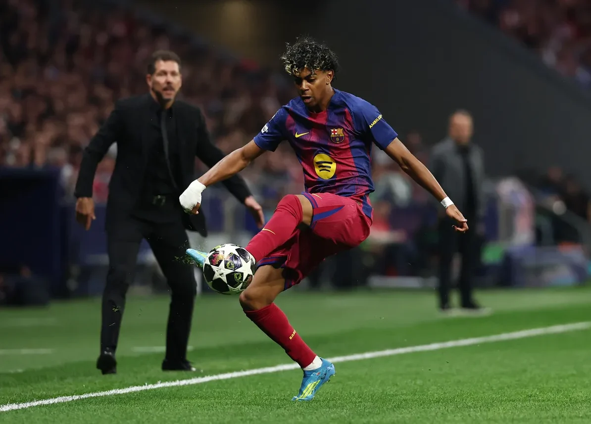 Fudbaler Barcelone u crveno-plavom dresu izvodi udarac.