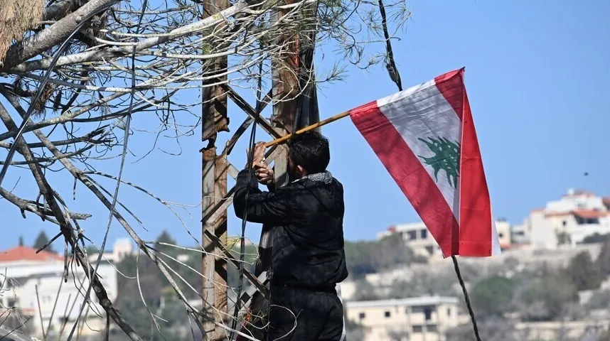 Čovjek sa libanonskom zastavom na drvetu