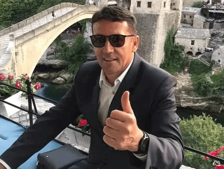 Muškarac u odijelu daje palac gore ispred Starog mosta u Mostaru.