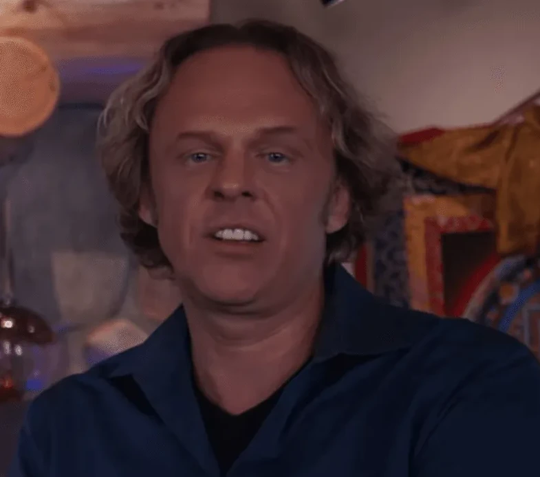 Muškarac sa plavom kosuljom i duzom kosom