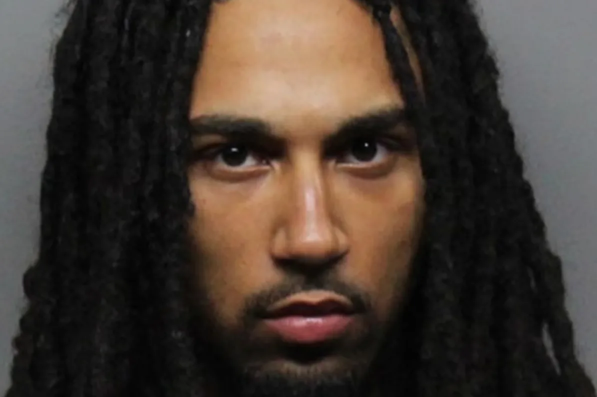 Muškarac sa tamnom kosom u dredlokovima i kratkom bradom