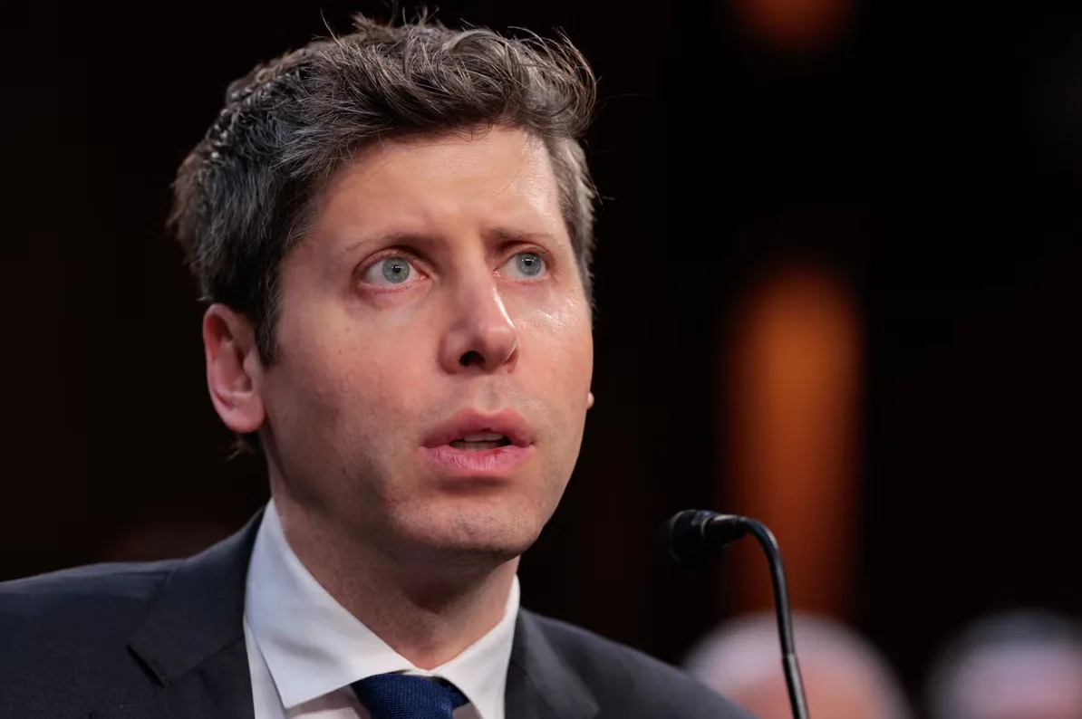 Portret muškarca sa sivom kosom i plavim očima koji govori na mikrofon.