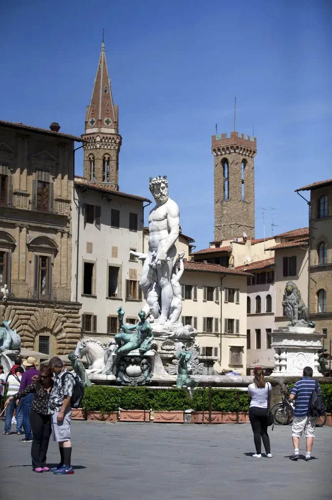 Grupa turista posmatra Neptunovu fontanu na Pjaci dela Sinjorija u Firenci, Italija.