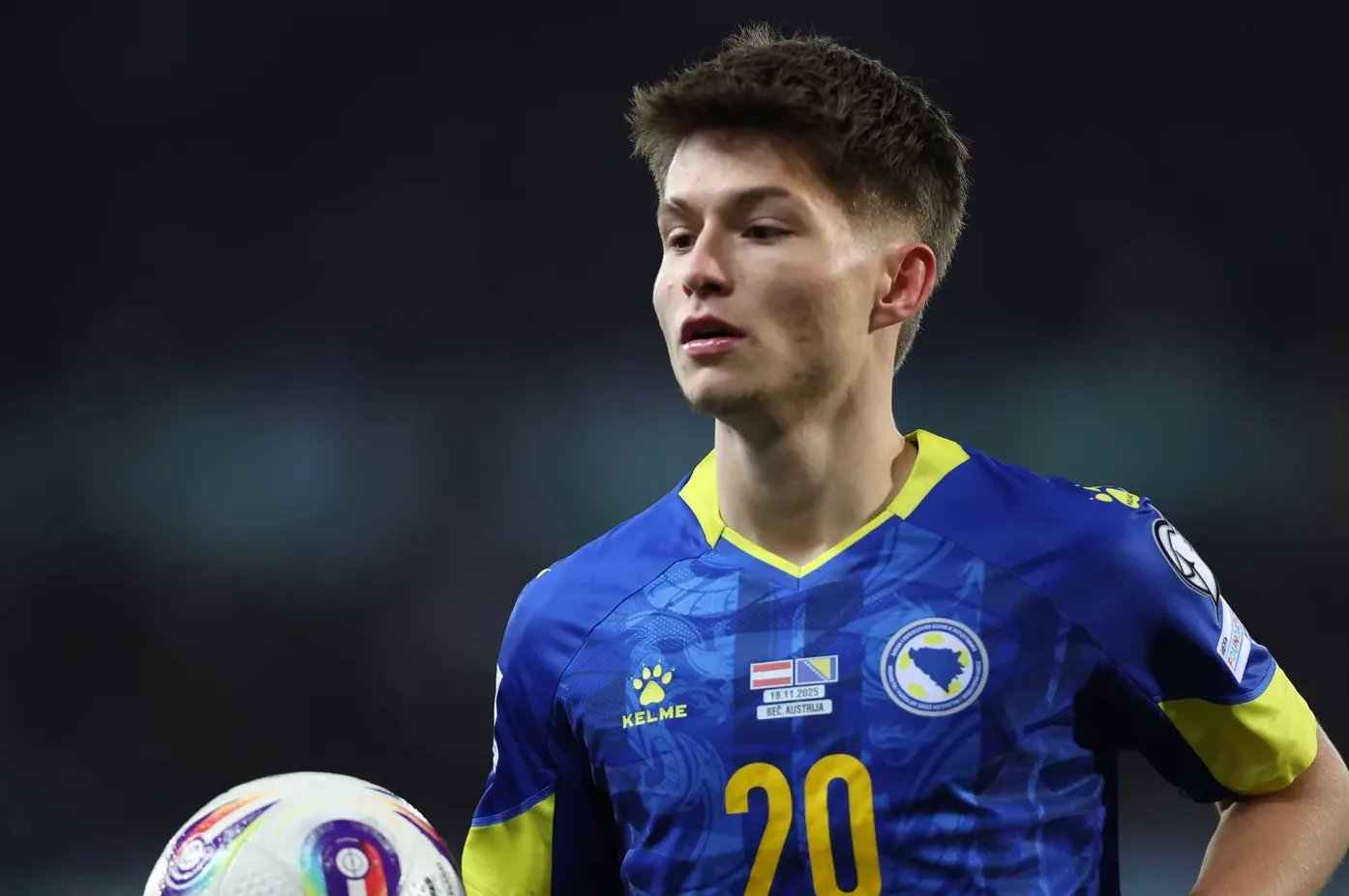 Fudbaler Bosne i Hercegovine sa brojem 20 na dresu, drži loptu.