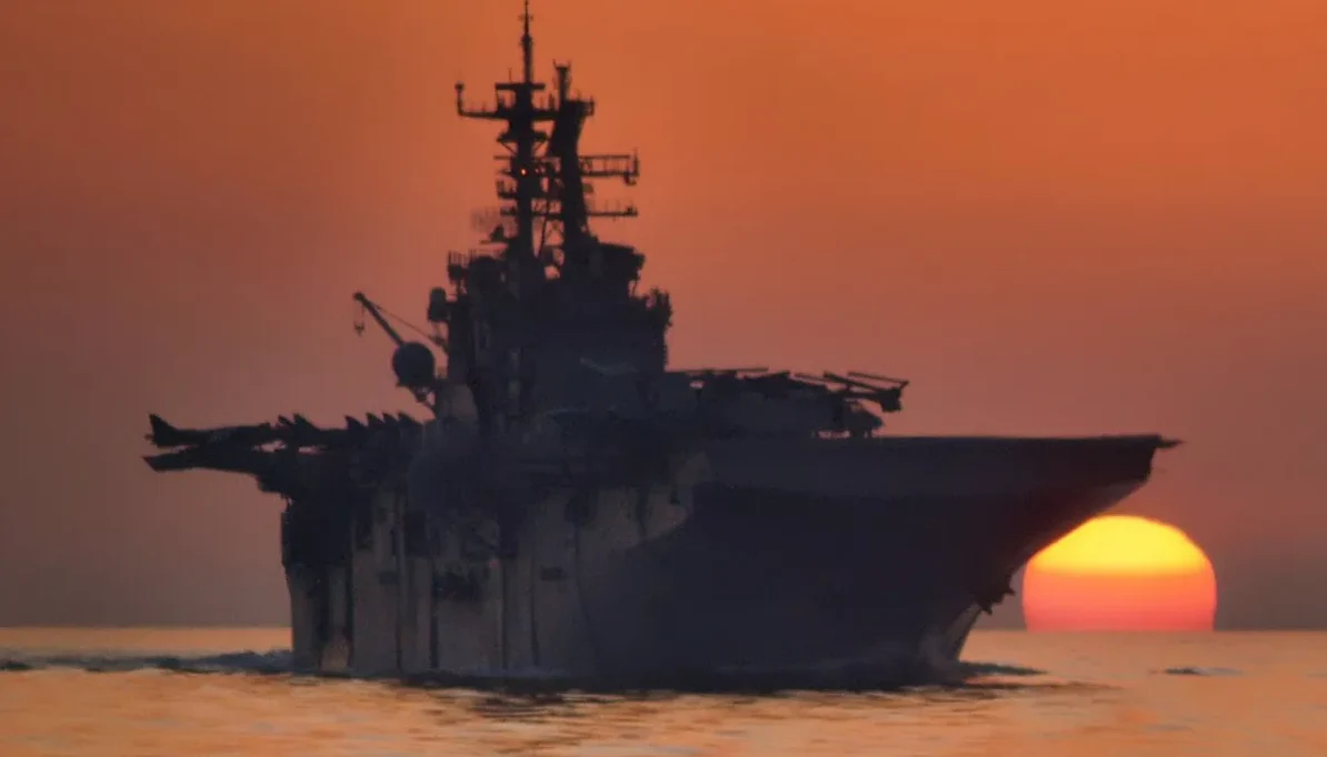 Nosac aviona na moru pri zalasku sunca