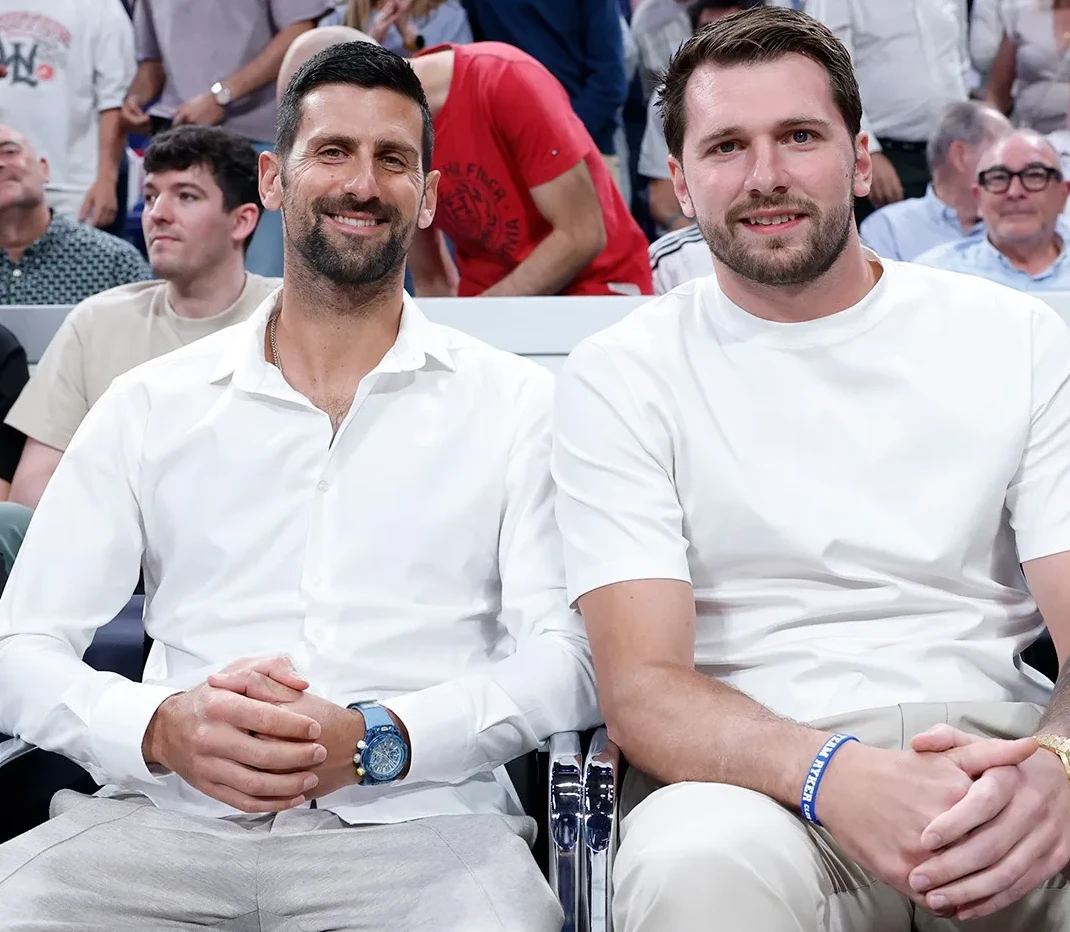 Novak Đoković i Luka Dončić sjede jedan pored drugog na tribinama.