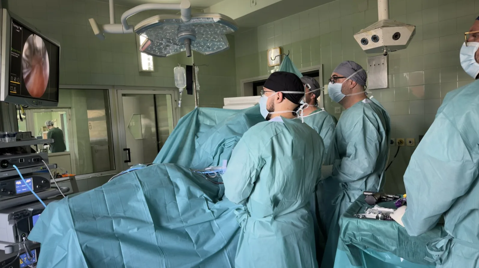 Hirurški tim tokom operacije, prikazan endoskopski snimak na monitoru.