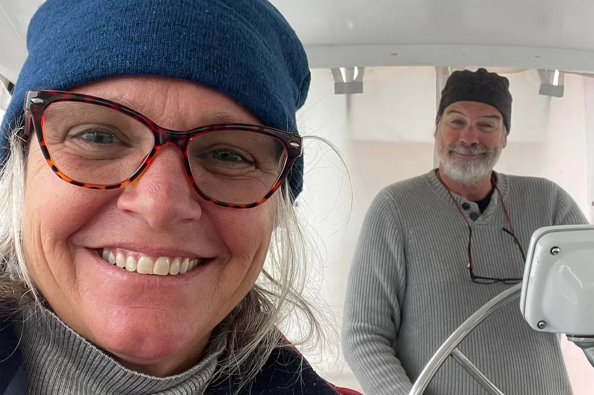 Srećni par nosi kapice i osmijehe dok poziraju za selfi na jedrilici