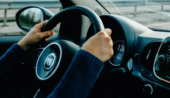 Ruke na volanu Fiat automobila, prikaz saobraćajne trake i brzinomjera.