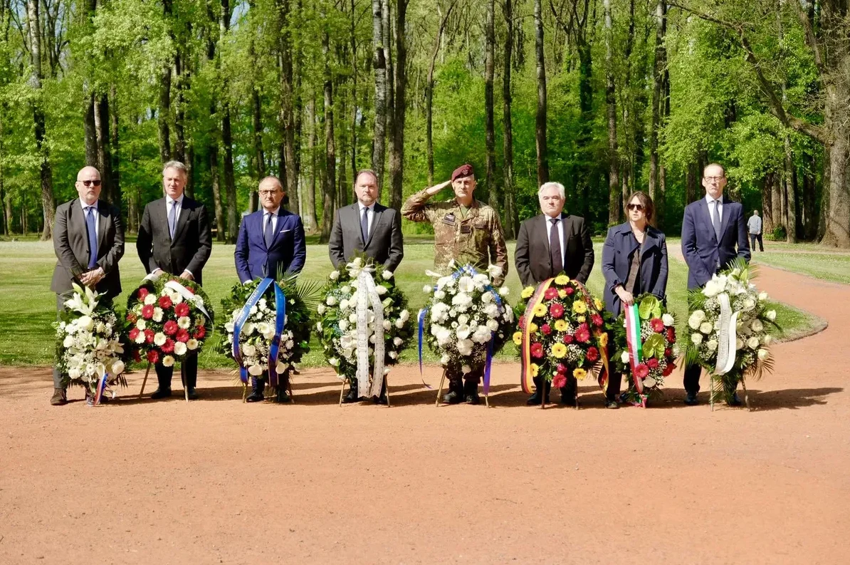 Grupa zvaničnika i vojnika polaže vijence u parku.