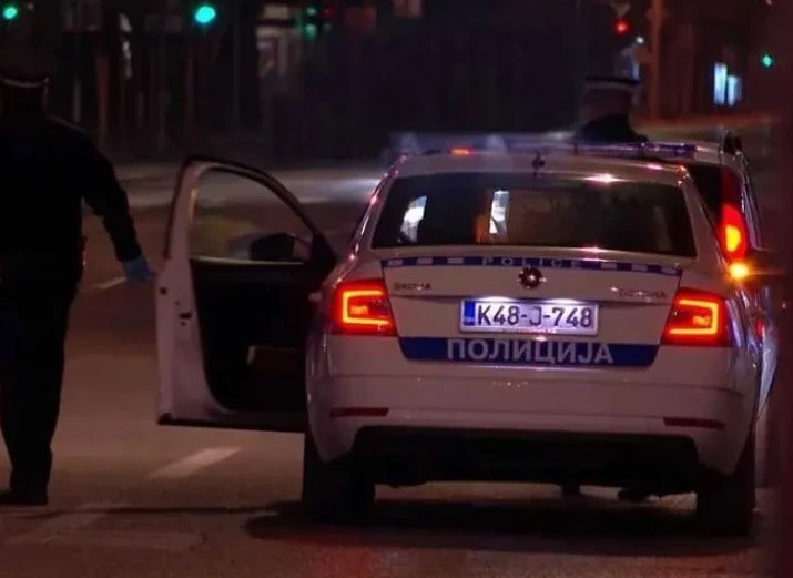 Policajac otvara vrata službenog policijskog vozila na kojem piše "POLICIJA"