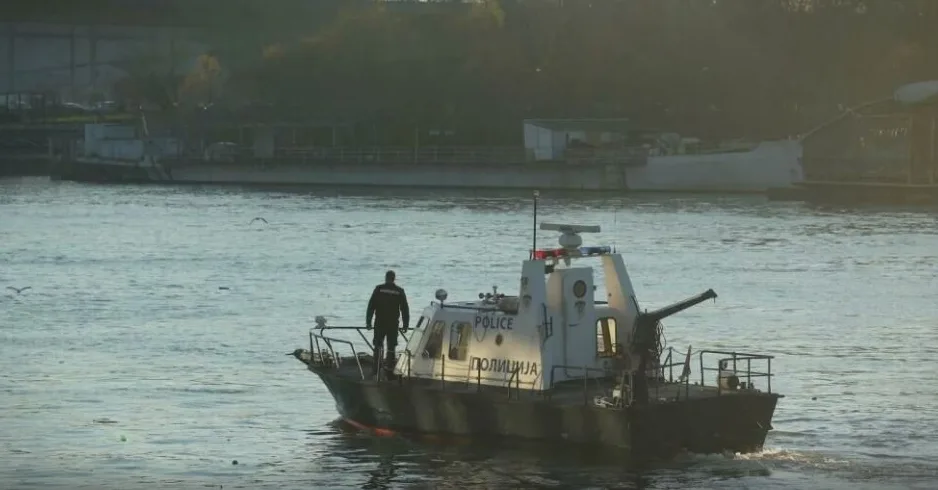 Policijski brod sa službenikom na palubi plovi rijekom.