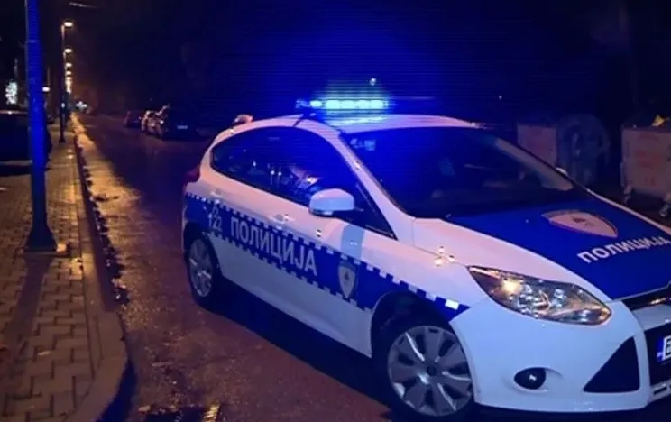 Policijsko vozilo sa uključenim plavim rotacijama na ulici noću.