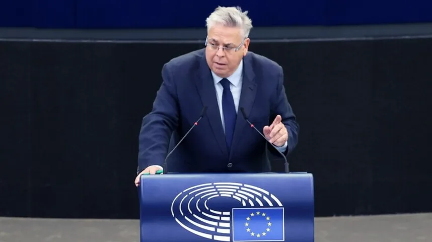 Političar u tamnom odijelu i plavoj kravati govori za govornicu u Evropskom parlamentu.