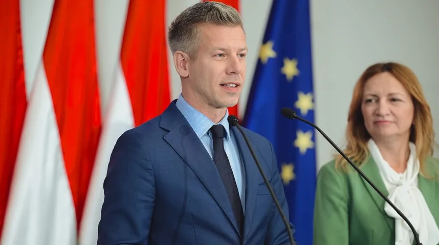 Političar govori pred mikrofonom s zastavom EU i zastavom Mađarske u pozadini.