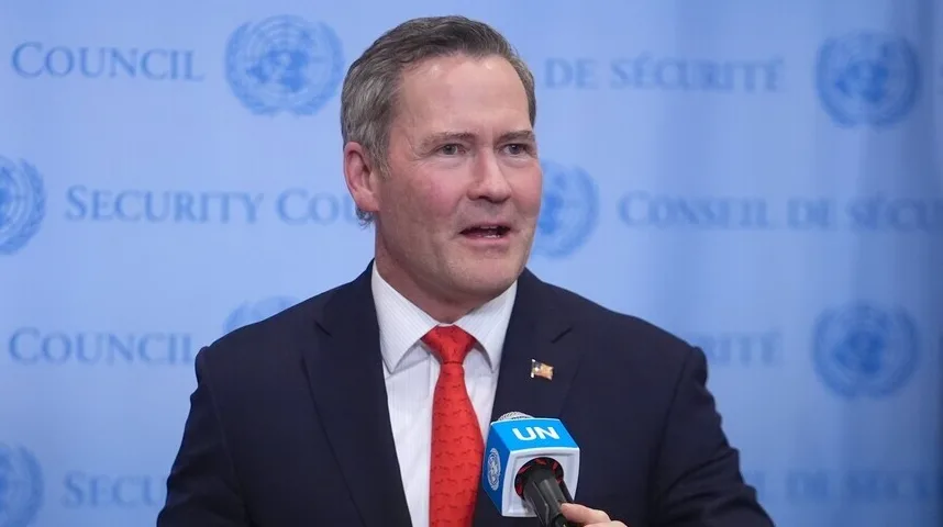 Političar u tamnom odijelu i crvenoj kravati govori u mikrofon sa logom UN-a, sa pozadinom "Security Council" na plavoj podlozi.