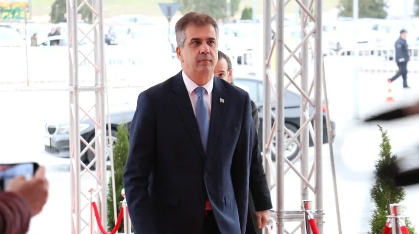 Političar u tamnom odijelu i plavoj kravati ide crvenim tepihom uz prisustvo obezbjeđenja i okupljenih ljudi.