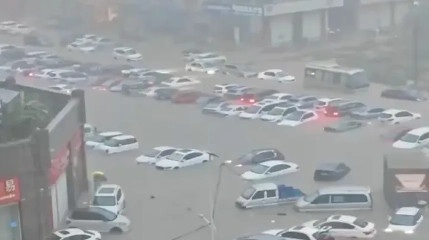 Poplava u gradu gdje su automobili parkirani u dubokoj vodi.