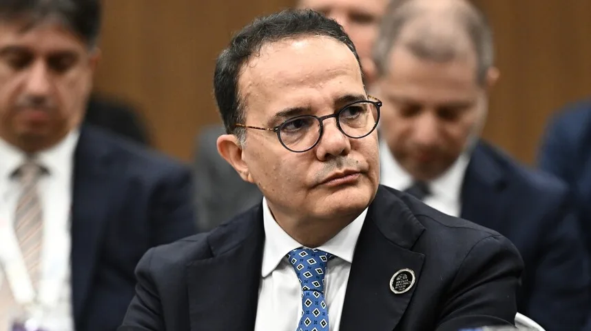 Portret muškarca sa naočarima, tamnim odijelom i plavom kravatom