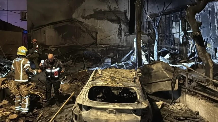 Vatrogasci pregledaju mjesto požara i izgorjeli automobil.