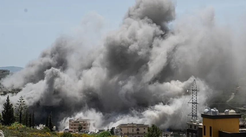 Gusta crna i siva dimna zavjesa diže se sa zgrada i zelenila u naseljenom području.