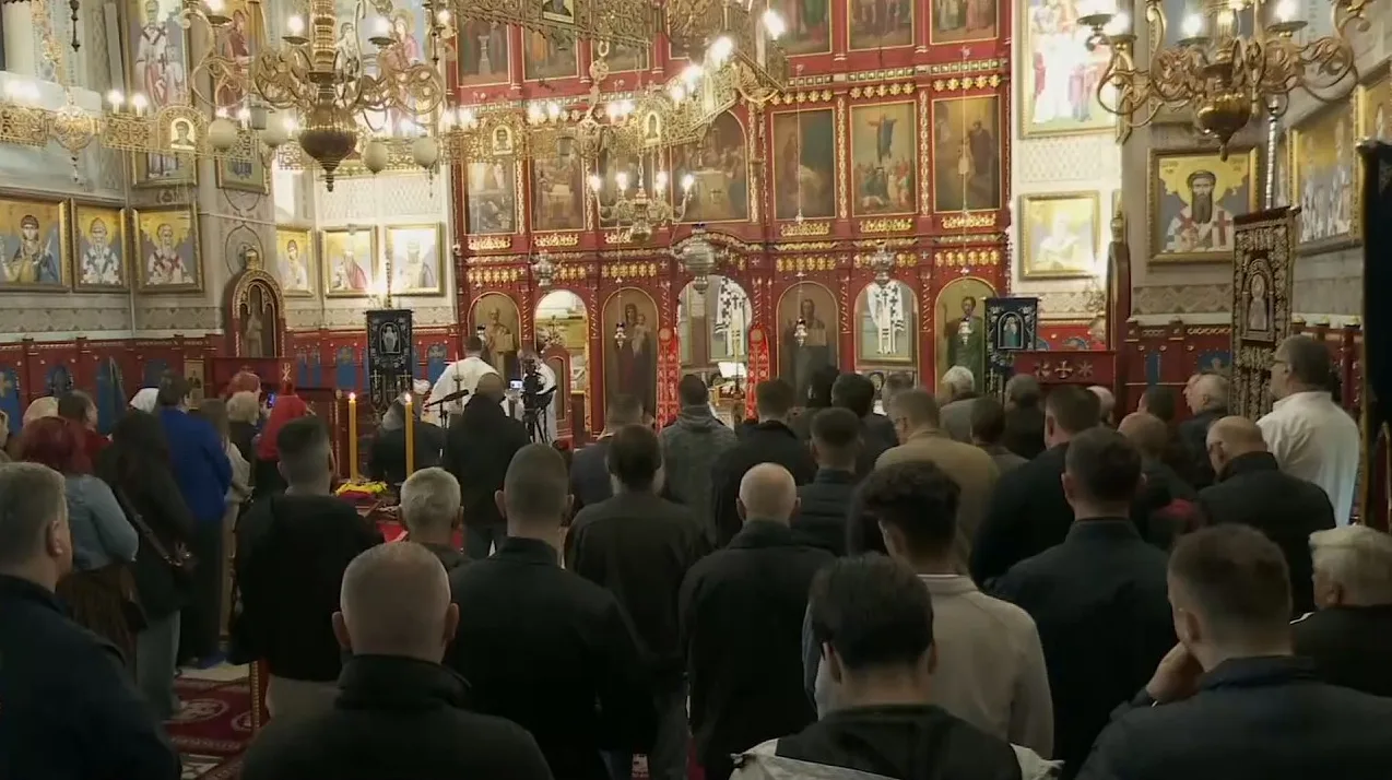 Unutrašnjost pravoslavnog hrama sa ikonama i vjernicima