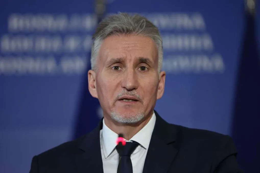 Portret muškarca sa sijedom kosom i bradicom, obučenog u tamno odijelo i bijelu košulju.