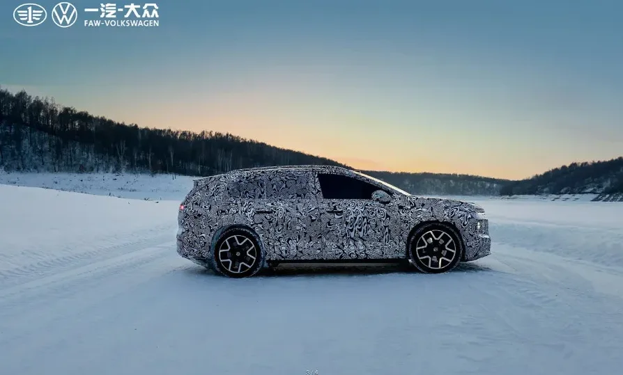 Novi FAW-Volkswagen prototip vozila prekriven maskirnom šarom kako bi se prikrio dizajn, testira se na zaleđenoj površini u zimskom pejzažu pri zalasku sunca.