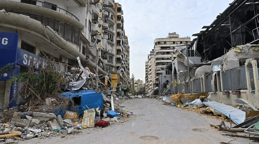 Srušena ulica u gradu sa oštećenim zgradama i gomilom šuta.