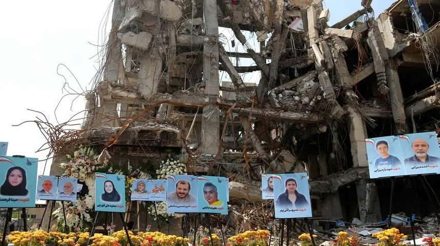 Srušena zgrada sa izloženim portretima osoba označenih kao šehidi.
