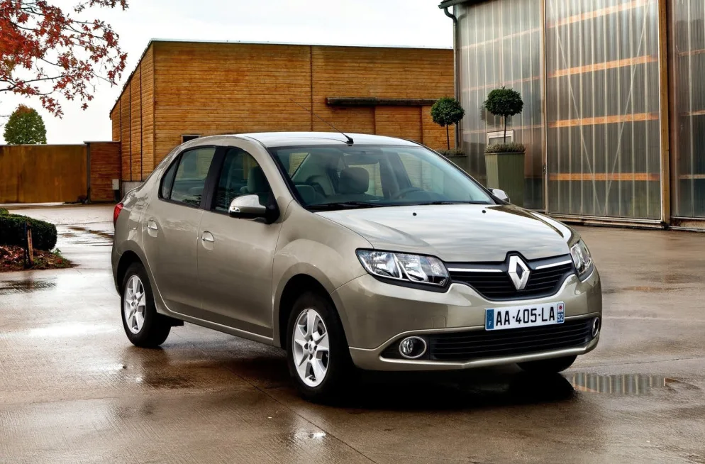 Svijetlotačkasti Renault Logan sedan parkiran na mokrom asfaltu