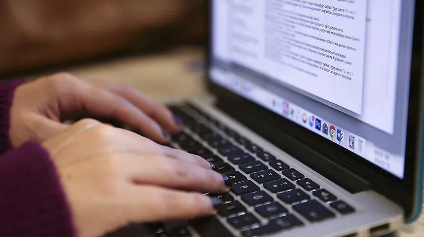 Ženske ruke pišu na tastaturi laptopa.