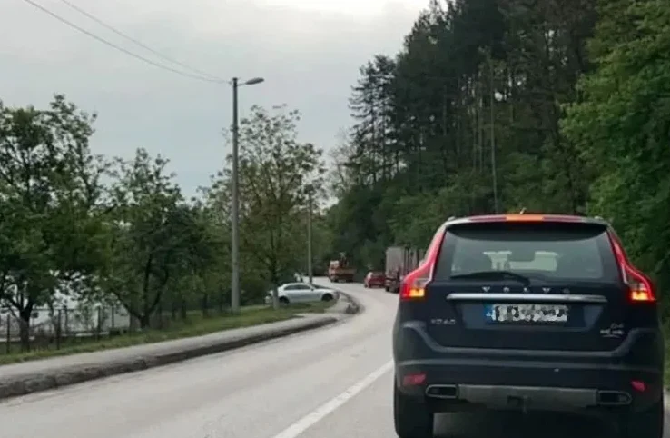 Saobraćaj na putu sa više vozila, uključujući Volvo i kamione, sa zelenilom sa strane.