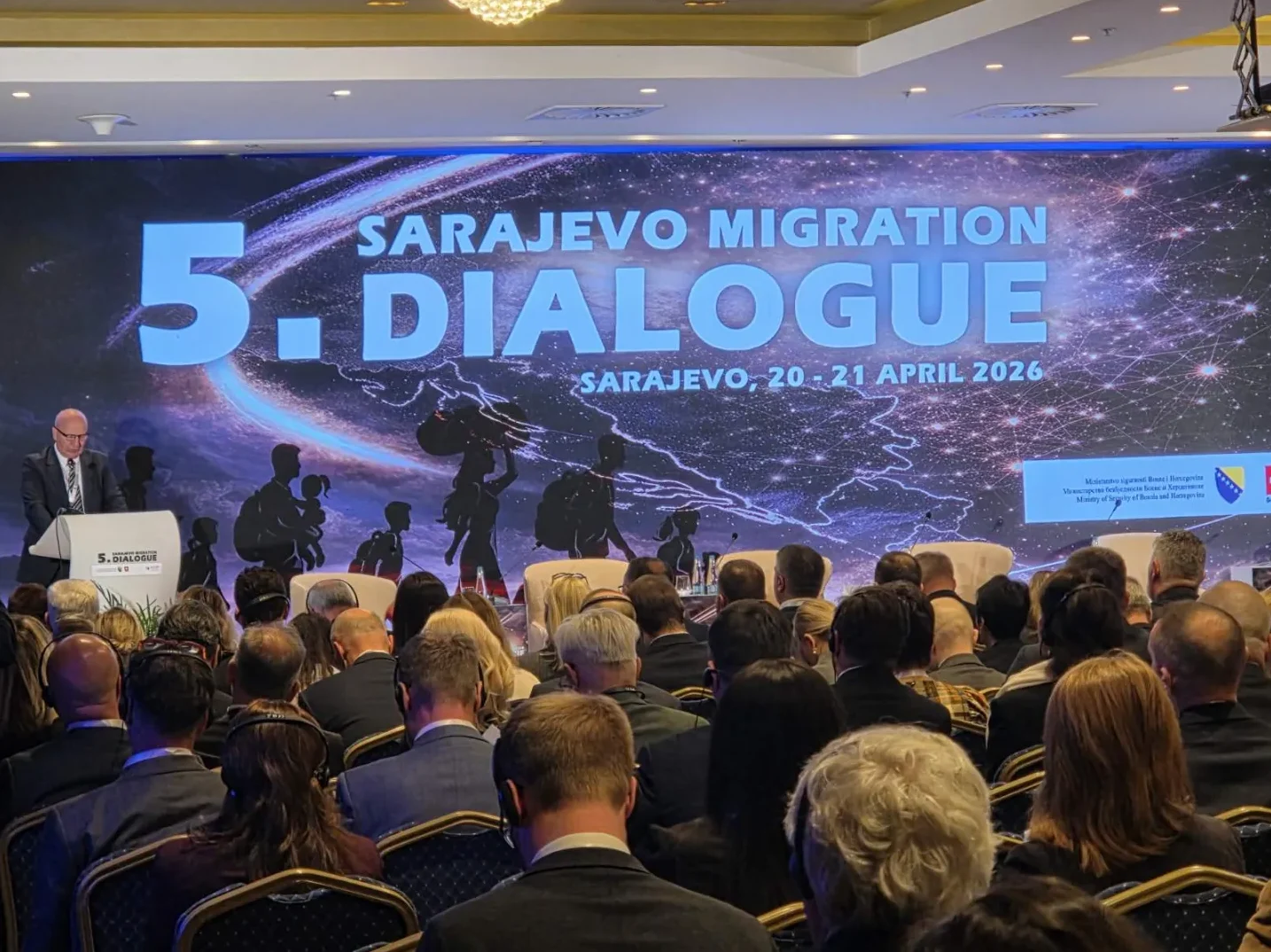 Gospodin u odijelu govori sa govornice na konferenciji o migracijama u Sarajevu.