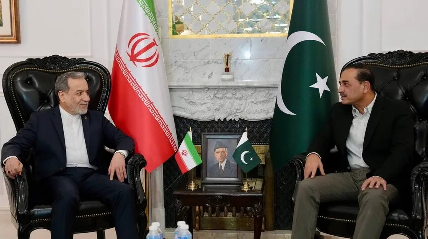 Dva zvaničnika sjede u kožnim foteljama, jedan sa iranskom zastavom iza leđa, a drugi sa pakistanskom zastavom. U sredini je slika osnivača Pakistana, Muhameda Alija Jinnaha, između manjih zastava obje države.