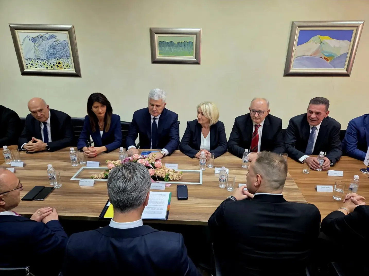 Grupa političkih zvaničnika sjedi za stolom tokom sastanka.