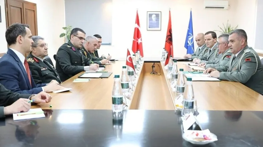 Vojni zvaničnici Turske i Albanije sjede za stolom na sastanku, sa zastavama obje zemlje i NATO-a u pozadini.