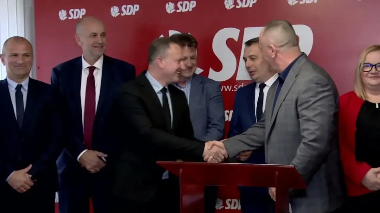 Političari rukuju se ispred SDP-ove pozadine