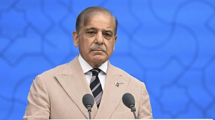 Premijer Pakistana, Shehbaz Sharif, stoji za govornicom sa dva mikrofona ispred plave pozadine sa šarom.