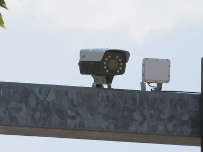 Sigurnosna kamera i radar instalirani na metalnom stubu, s pogledom na nebo.
