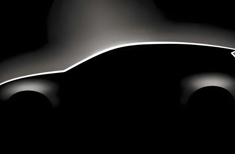Silueta novog automobila obasjana jarkim svjetlom na crnoj pozadini.