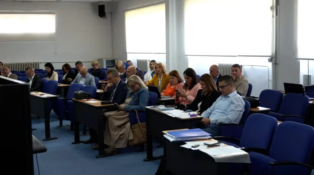 Grupa ljudi sjedi u auditorijumu i sluša predavanje.