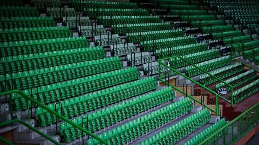 Prazne zelene tribine stadiona sa stepeništima i rukohvatima.